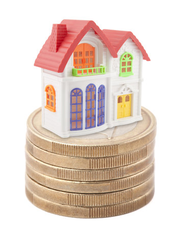 Colorful toy house on stack of euro coinsの写真素材