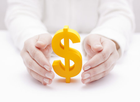 Golden dollar symbol protected by handsの写真素材