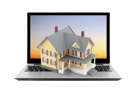 Yellow house on laptop isolated on whiteの写真素材