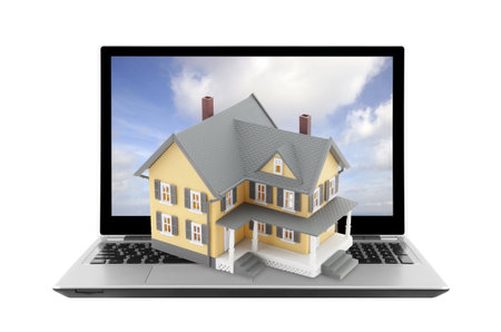 Yellow house on laptop isolated on whiteの写真素材