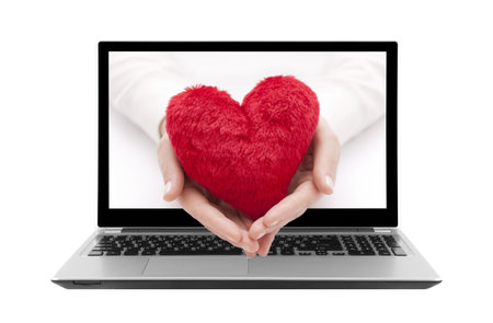 Laptop with red heart in woman handsの写真素材