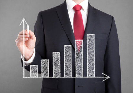 Businessman drawing a growing chart with chalkの写真素材