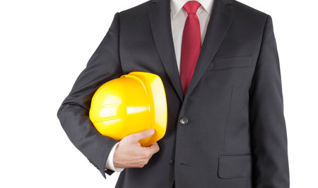 Engineer in black suit holding helmet isolated on white with clipping pathの写真素材