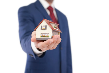 Small toy house in hand isolated on white with clipping pathの写真素材