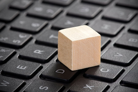 Wooden block on laptop keyboardの写真素材