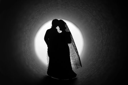 Marriage crisis. Bride and groom figurines in a dark tunnel.の写真素材