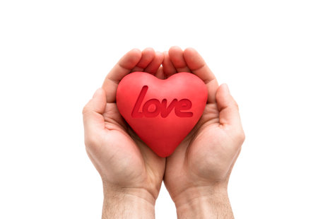 Red heart with imprinted love word in man's hands.の写真素材