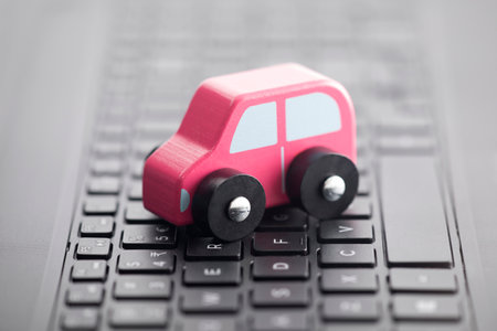 Wooden car toy on laptop keyboard