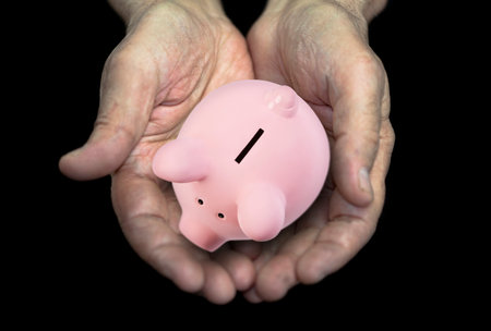 Old hands with piggy bank, pension conceptの写真素材