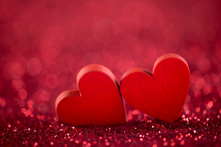 Two red hearts on glitter background in love conceptの写真素材