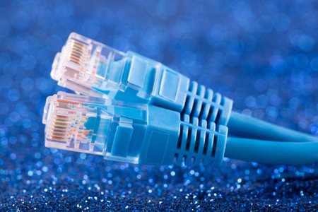 Two network cables over blue sparkles backgroundの写真素材