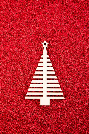 Wooden Christmas tree shape on red glitter backgroundの写真素材