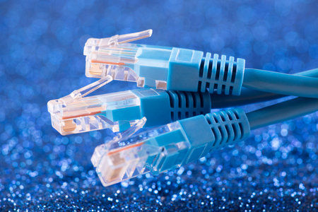 Three network cables over blue sparkles backgroundの写真素材