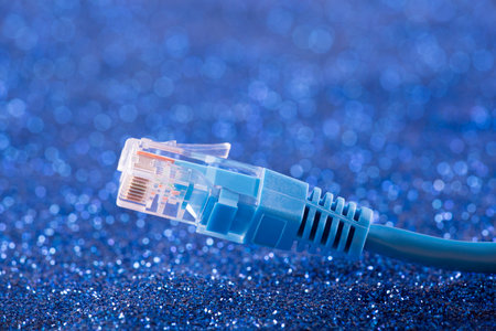 Network cable over blue sparkles backgroundの写真素材