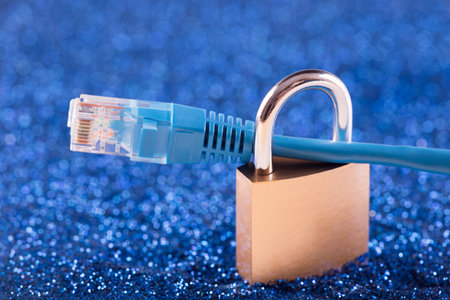 Internet security concept. Padlock with internet cable over blue sparkles backgroundの写真素材