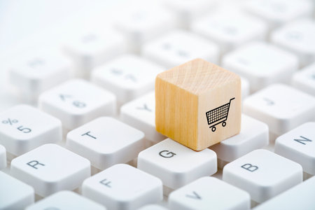 Wooden block with shopping cart graphic on computer keyboard. Online shopping concept.の写真素材