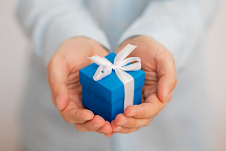 Small blue present box in handsの写真素材
