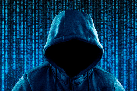 Anonymous hooded computer hacker portrait on computer code background