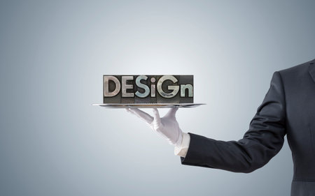 Businessman offering design word on silver trayの写真素材
