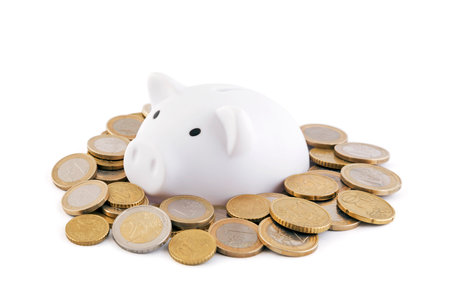 White piggy bank with euro coins on white backgroundの写真素材