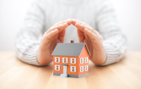 Small orange house covered by handsの写真素材