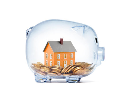 Orange house on money inside transparent piggy bankの写真素材