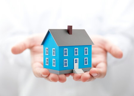 Small blue toy house in handsの写真素材