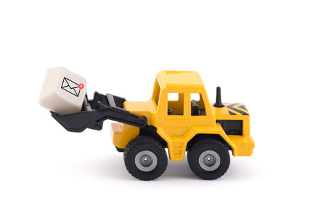 Bulldozer with new email graphic on computer key isolated on white background with clipping pathの写真素材