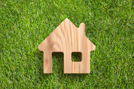 Wooden house shape on green grassの写真素材