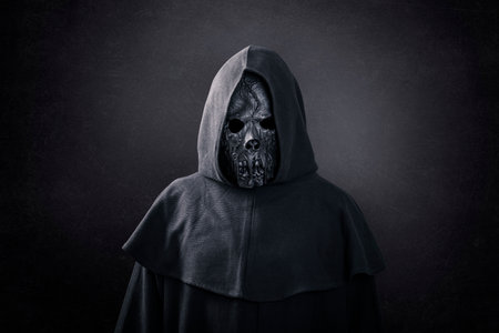 Scary figure in hooded cloak in the darkの写真素材