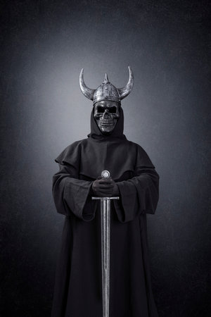 Skeleton warrior with horned helmet and sword in the darkの写真素材