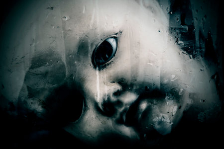 Creepy doll face behind the old glass