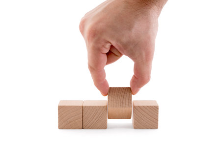 Businessman changes blank wooden block on white backgroundの写真素材