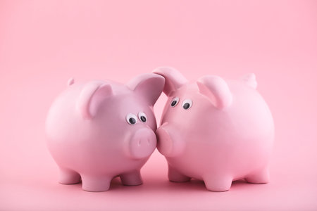 Two pink piggy banks on pink backgroundの写真素材