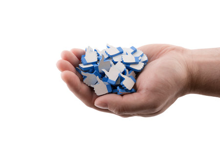 Many blue like thumb up icons in hand isolated on white backgroundの写真素材