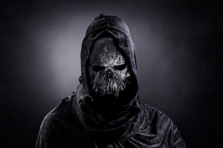 Monster in hooded cloak at night over dark misty backgroundの写真素材