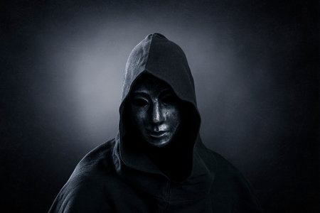 Scary figure with hooded cloak in the darkの写真素材