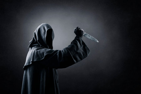 Hooded man with old knife in the darkの素材 [FY310181136550]