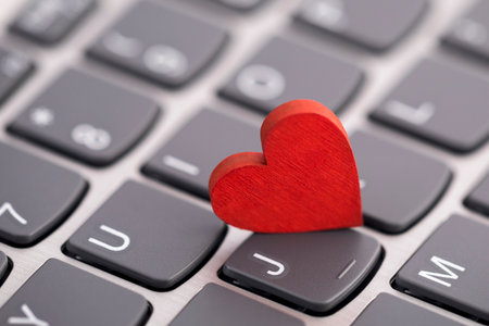 Small red heart on computer keyboard. Internet dating concept.