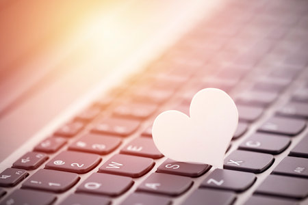 Small white paper heart on computer keyboard. Internet dating concept.の写真素材