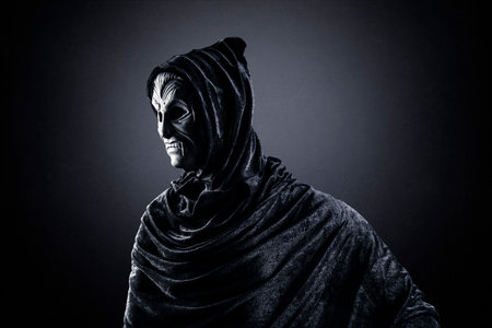 Vampire with cape showing his scary teeth over dark misty backgroundの写真素材