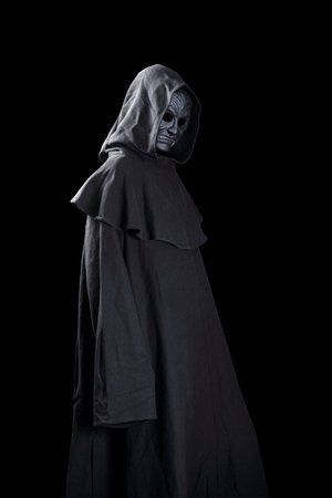 Vampire with cape showing his scary teeth isolated on black backgroundの写真素材