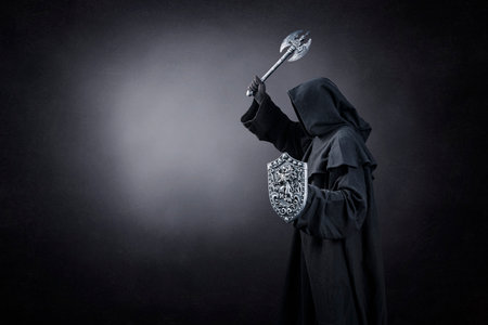 Dark knight with ax and shield over dark misty backgroundの写真素材