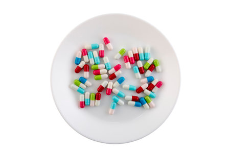 Colorful pills on a plate isolated on white background with clipping pathの写真素材