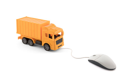 Yellow cargo delivery truck miniature connected to computer mouse on white backgroundの写真素材