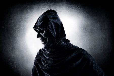 Scary figure with hooded cloak in the darkの素材 [FY310204573073]