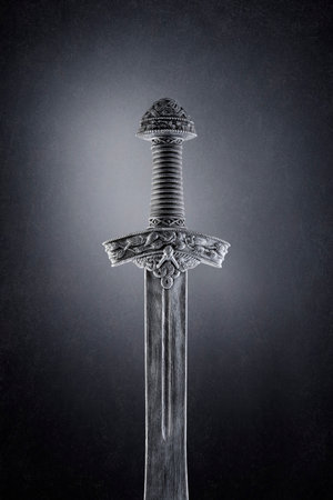 Medieval sword over dark misty backgroundの写真素材