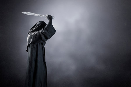 Dark knight with hooded cape and medieval sword over dark misty backgroundの写真素材
