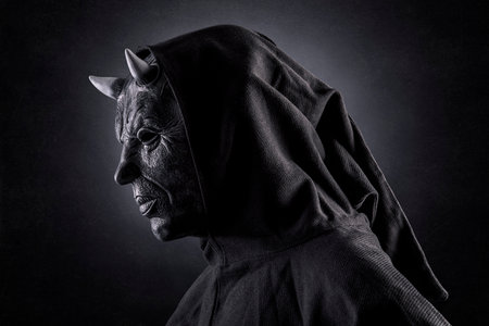 Portrait of a bad devil with horns on head over dark misty backgroundの写真素材