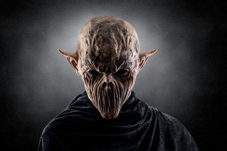 Portrait of a creepy monster over dark misty backgroundの写真素材